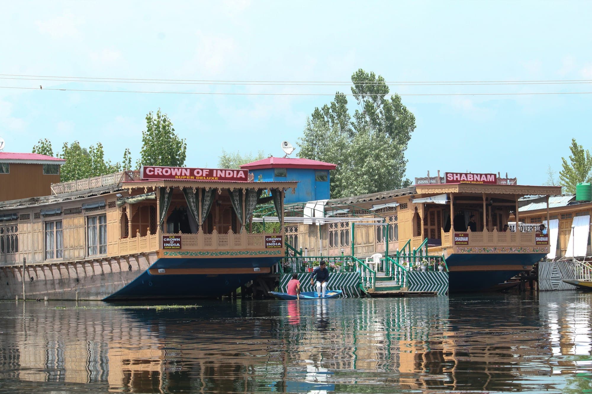 Traditional shikara boat on Dal Lake with the Kashmir mountains behind