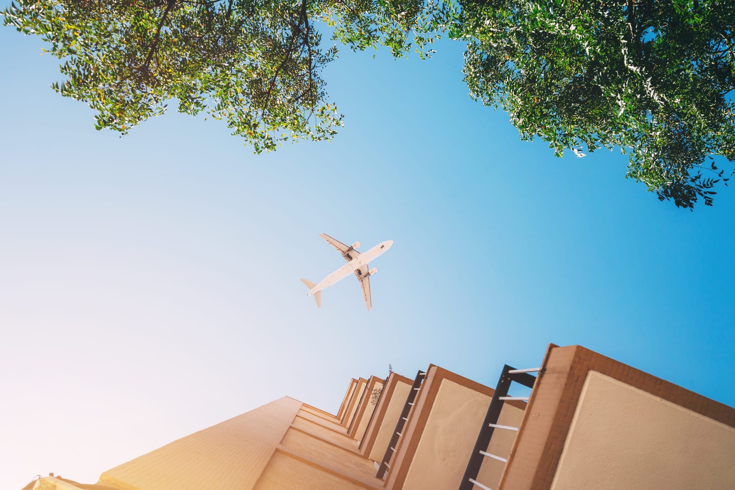 Airplane flying overhead between city buildings