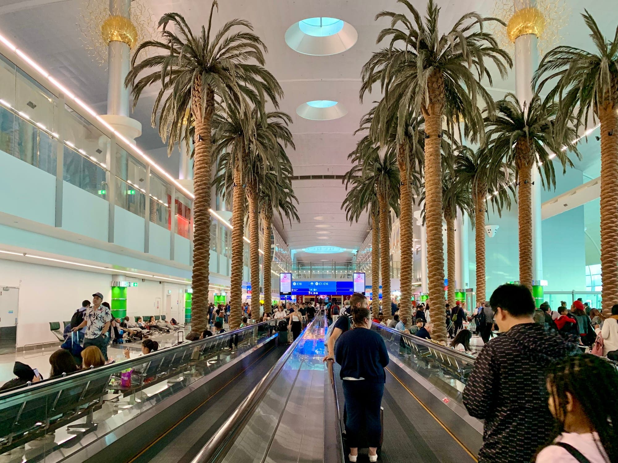 Interior of Dubai International Airport terminal with travellers walking through